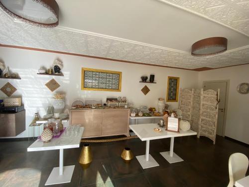 a living room with two tables and a counter at RIAD Comfort Rooms in San Vito lo Capo