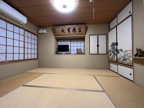 an empty room with a television in a room with windows at PLATINUM kitaoji in Kyoto