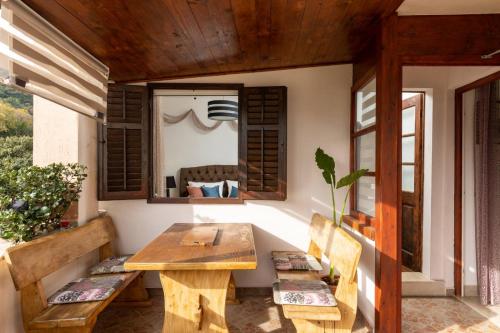 a room with a table and benches and a window at Bougainvillea in Ston