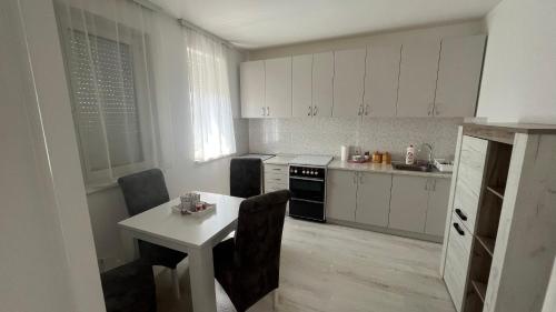 帕拉欽的住宿－Harmony Relax，厨房配有白色橱柜和白色的桌椅