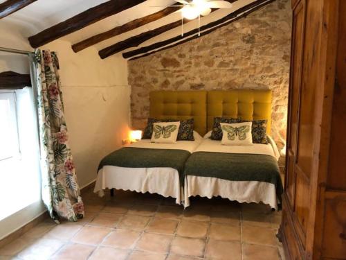 um quarto com uma cama com uma parede de tijolos em Las Casas del Rincón -4 dormitorios em Villahermosa