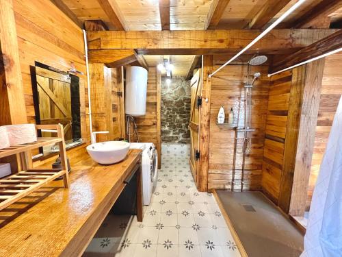 baño con lavabo y ducha con paredes de madera. en La Cabaña María, en San Roque de Ríomiera