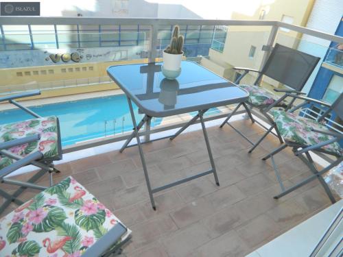 uma mesa e cadeiras numa varanda com piscina em BLUE 470 em Isla Cristina