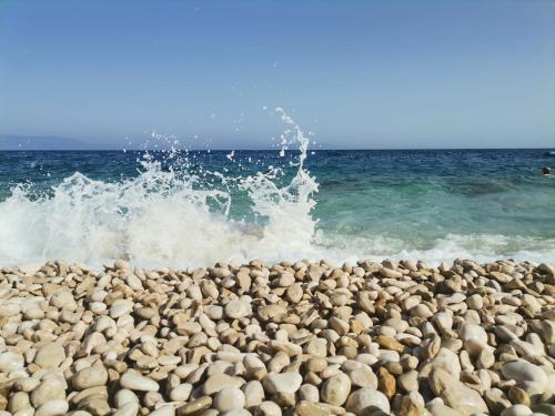 a pile of rocks on a beach with the ocean at Lovely apartment Branko Rabac with balcony and parking in Rabac