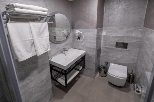 a bathroom with a sink and a toilet and a mirror at Avion Suite Hotel in Antalya