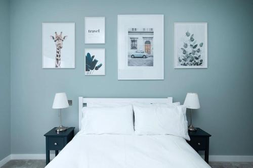 a bedroom with a white bed with pictures on the wall at Oak Tree Lodge in London