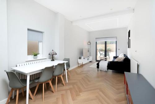 a white living room with a dining table and chairs at Oak Tree Lodge in London