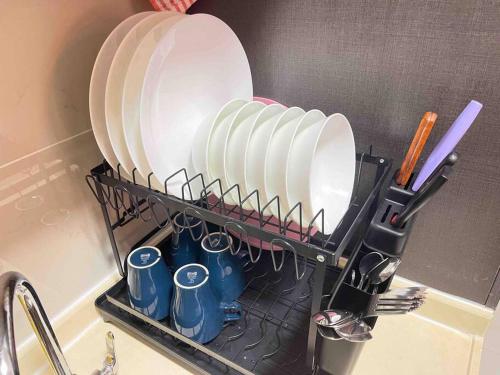 a dish rack with plates and cups on a sink at Country Garden Danga Bay by WP HOMESTAY in Johor Bahru