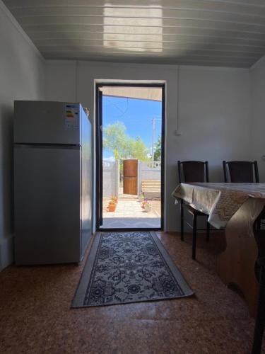 a kitchen with a refrigerator and a table and a door at Tunuk Guest House in Tossor