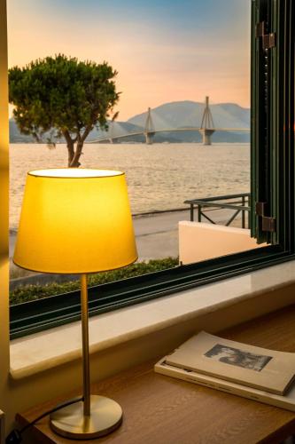 a lamp sitting on a desk next to a window at Rio Beach Residence in Patra
