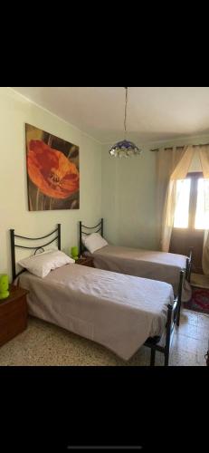 a bedroom with two beds and a painting on the wall at La massaria di Cesare in Pianella