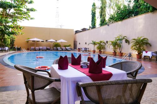 a restaurant with a table and chairs next to a pool at Royal Palace Hotel in Juba