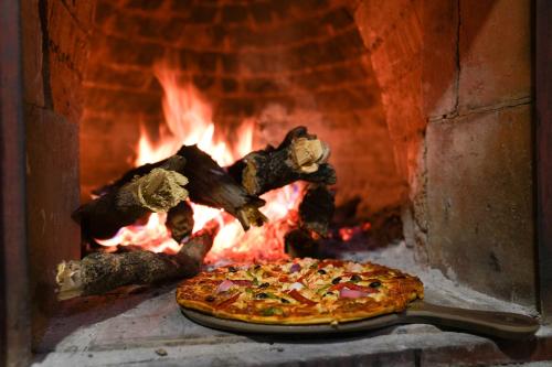 a pizza is being cooked in a brick oven at Royal Palace Hotel in Juba
