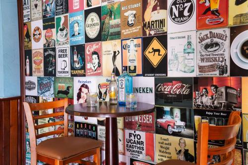 a table and two chairs in front of a wall with posters at Royal Palace Hotel in Juba