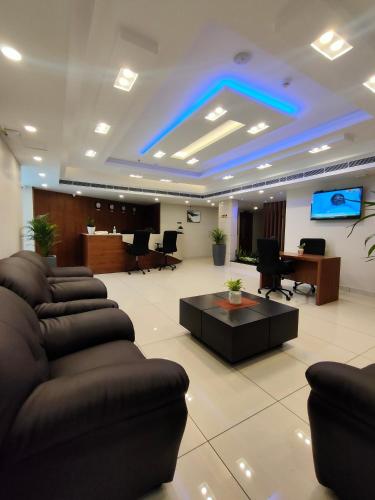 a lobby with couches and a tv in a room at Lumbini Supreme in Trichūr
