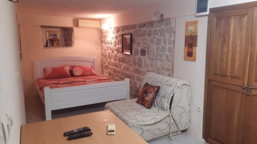 a small room with a bed and a chair at Apartments Lanmari in Risan