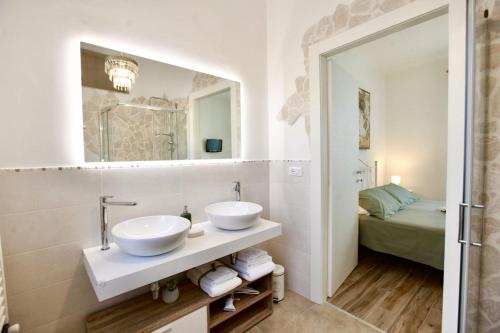 a bathroom with two sinks and a mirror at B&B Casa Alinella, Happy and Sustainable Hospitality in Taranto