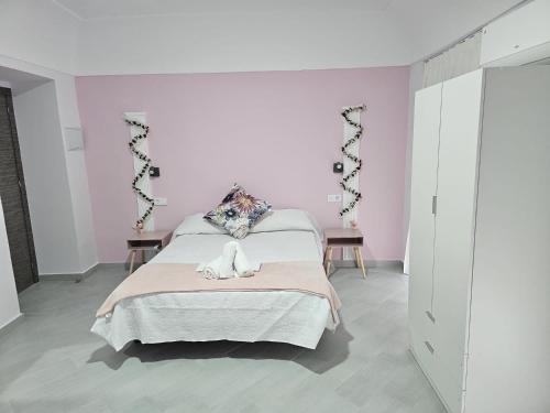 a bedroom with a bed in a white room at Hostal Pompeya Merida in Merida