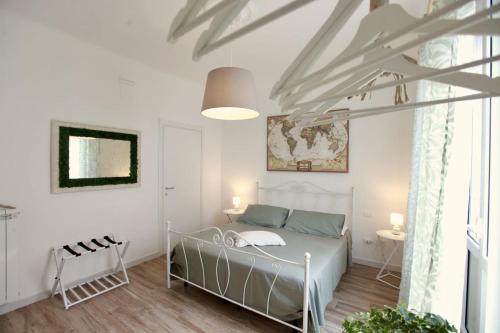 a bedroom with a bed in a white room at B&B Casa Alinella, Happy and Sustainable Hospitality in Taranto