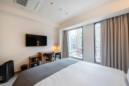 a bedroom with a bed and a large window at The knot Sapporo - Vacation STAY 96399v in Sapporo
