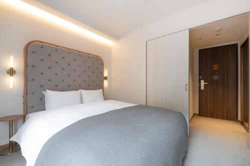 a bedroom with a large white bed and a door at The knot Sapporo - Vacation STAY 96399v in Sapporo