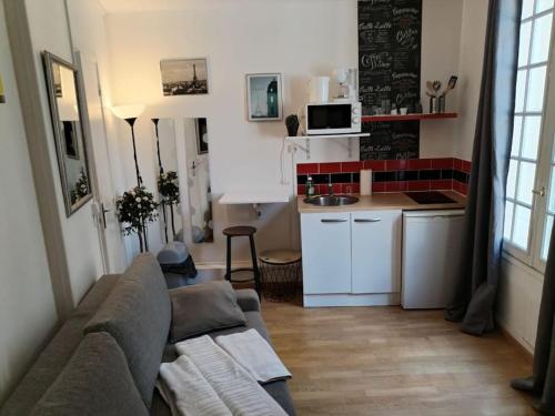 sala de estar con sofá y cocina en Studio Rue de la Santé, en París