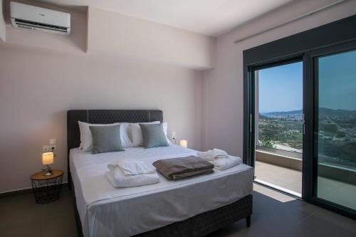 a bedroom with a large bed with a large window at Villa Aurora in Faliraki