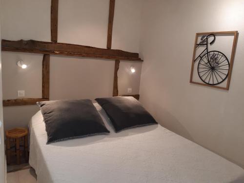- une chambre avec un lit et un vélo sur le mur dans l'établissement La ferme de Manon, à Montferrat