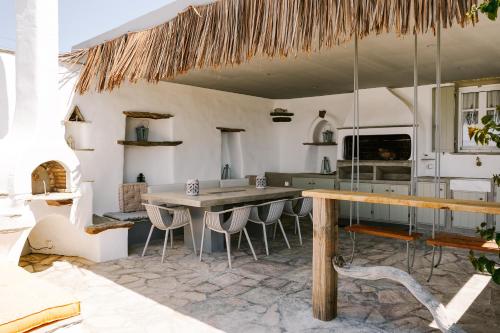 Maison Simone with private heated infinity pool & spectacular sea view في أيوس سوستيس: مطبخ مع طاوله وبعض الكراسي