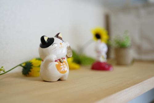 a toy cat figurine sitting on top of a counter at Kameari 911 Budget Stay High Floor Near Station Mall Disney Access in Tokyo