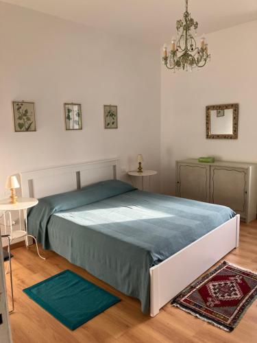 sypialnia z łóżkiem i żyrandolem w obiekcie Cascina delle Rose w mieście Sarzana