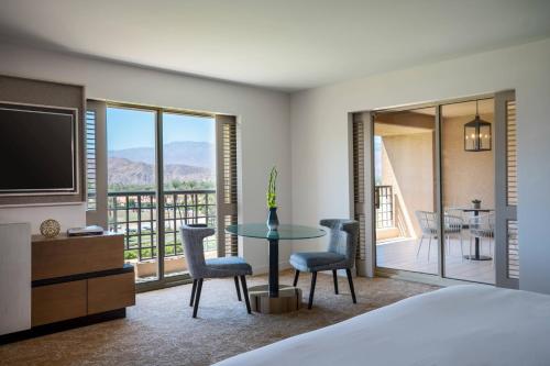a bedroom with a bed and a table with chairs at Renaissance Esmeralda Resort & Spa, Indian Wells in Indian Wells