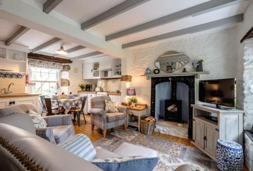 a living room with couches and a fireplace at Escape to Ancarva Cottage near Falmouth in Perranwell