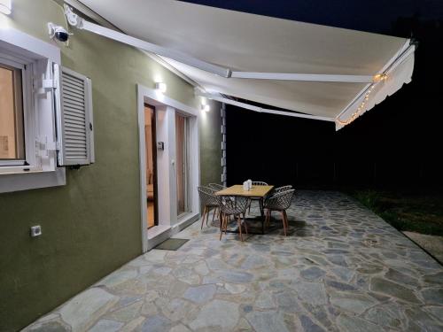a patio with a table and chairs next to a building at MemRo Village House in Atsoupádhes