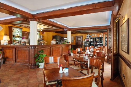 La Vecchia Fonte Boutique Hotel في بالاو: مطعم بطاولات وكراسي خشبية وبار