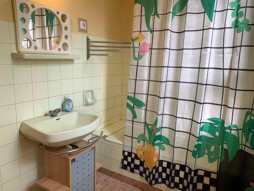 ein Bad mit einem Waschbecken und einem Duschvorhang in der Unterkunft Holiday home in Szantod/Balaton 20220 in Szántód