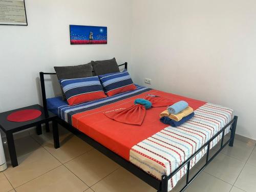 a bedroom with a bed with a red and blue comforter at White Paradise in Paleo Tsifliki