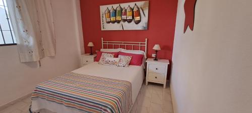 ミハス・コスタにあるEl Arcoの赤い壁の小さなベッドルーム(ベッド付)