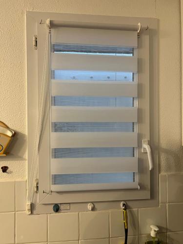 - une fenêtre avec un volet blanc dans la salle de bains dans l'établissement Les Amareyeurs - Ile d'Oléron - Maison classée 3 étoiles avec piscine - Clim - Vélos, au Château-dʼOléron