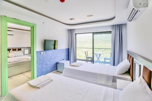 a hotel room with two beds and a balcony at Stonehillkaş in Kas