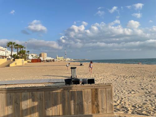 a woman standing on a beach with the ocean at Vistas al mar a 10 metros de la Playa de Regla PARKING GRATIS in Chipiona
