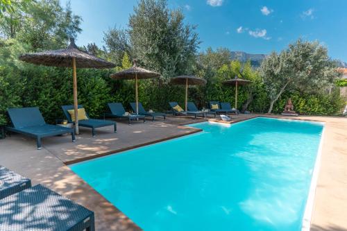 a swimming pool with chairs and umbrellas at Boho Suites Denia in Denia