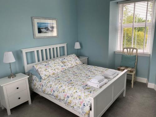 GarliestonにあるOld Station House - Kilfillan Cottageの青いベッドルーム(ベッド1台、椅子付)