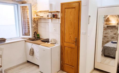 una pequeña cocina con fregadero y puerta en Falcons Nest, en Šibenik