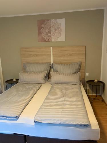 ein großes Bett in einem Zimmer mit 2 Tischen in der Unterkunft Ferienwohnung KaRo in Bodensdorf
