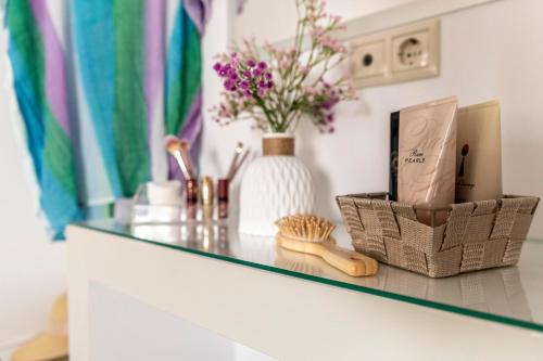 a glass counter top with flowers and a vase at Georgia Apartment in Matala