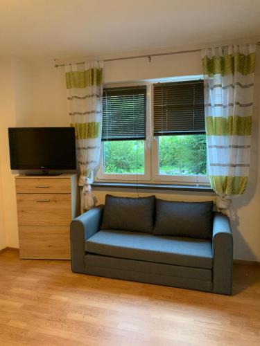 a living room with a couch and two windows at Ferienwohnung KaRo in Bodensdorf