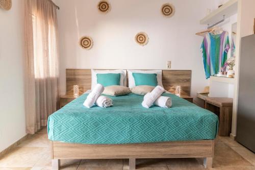 a bedroom with a bed with a green comforter and pillows at Georgia Apartment in Matala