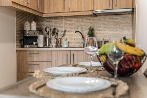 a table with two glasses and a bowl of bananas at Georgia Apartment in Matala