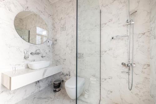 a bathroom with a shower and a toilet and a sink at Boutique Hotel Manufactura in Tbilisi City